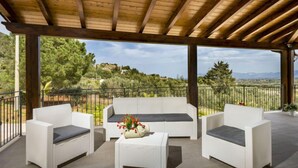 An outdoor patio with wicker furniture and a view of a hilly landscape. - Mari e Monti by Interhome (Castellammare del Golfo)