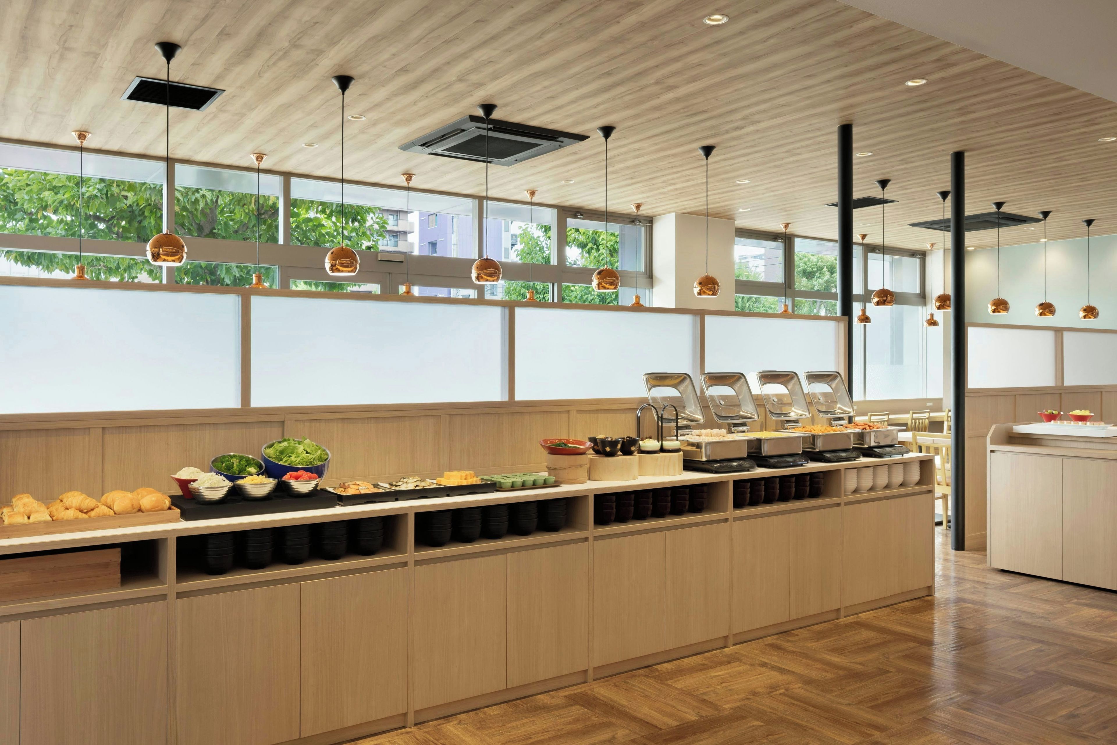 A modern buffet setup with a variety of food items and a wooden interior design.