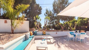 Un patio al aire libre con asientos, mesas y sombrillas.