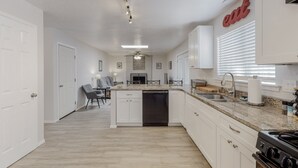 A modern kitchen with white cabinets, a granite countertop, and a dishwasher. - NEW Renovated Private 3/2Home(King)Near Balloon Fiesta Park, Quiet Neighborhood! (Albuquerque)
