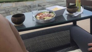 Una mesa de comedor con comida y bebidas, con vista a una playa.