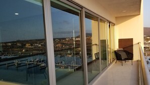 A balcony with a view of a marina and buildings.