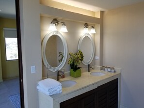A bathroom with two sinks, a large mirror, and a towel rack.
