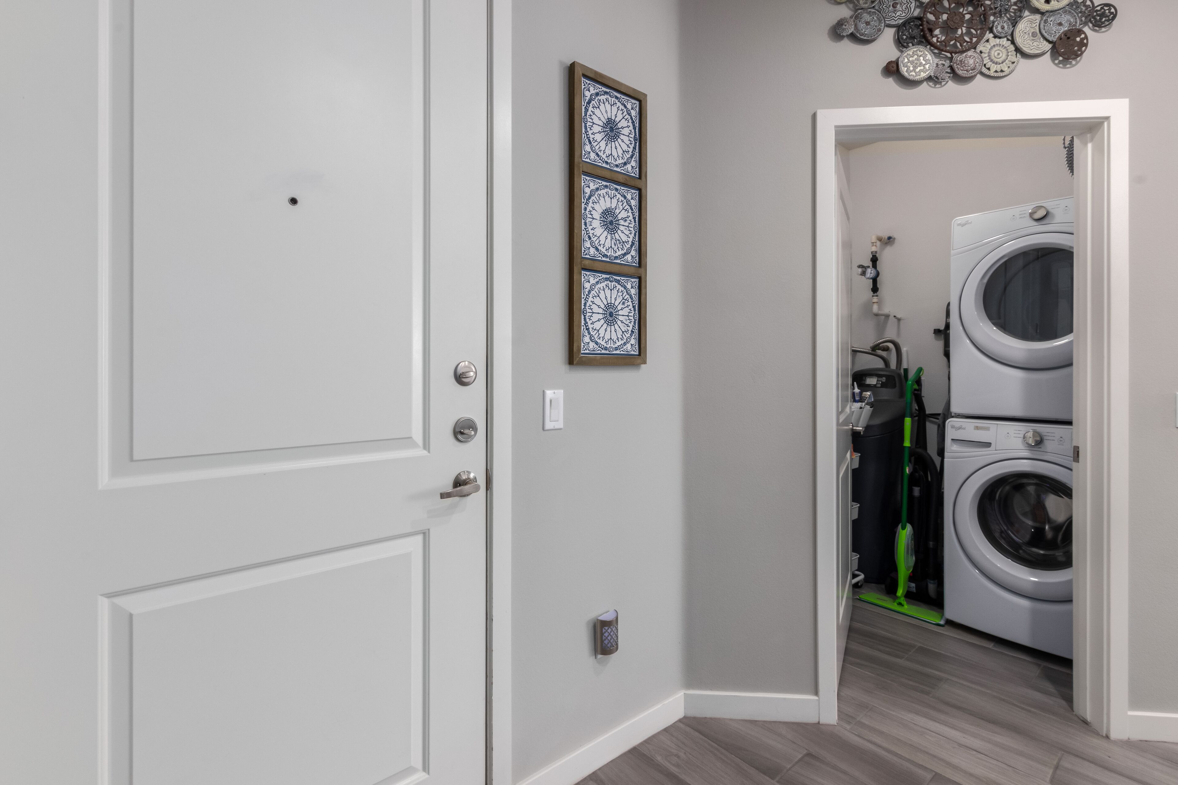 A hallway with a door leading to a laundry room.