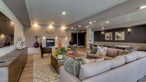 A modern living room with a fireplace, sofa, and dining area.