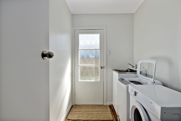 A laundry room with a door, a washing machine, and a dryer.