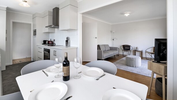 A modern, well-lit apartment with a kitchen, dining area, and living space. - Bach on Pitau - Mt Maunganui Holiday Home (Mt Maunganui)