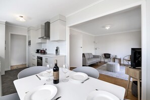 A modern, well-lit apartment with a kitchen, dining area, and living space.