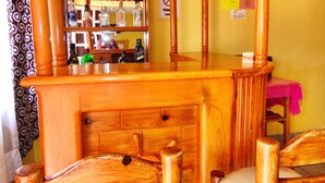 A wooden bar area with shelves of liquor bottles, a mirror, and a pink tablecloth. - Nice Apartment Near The Center Ground Floor (Zacatlán)