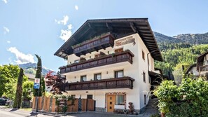 A multi-story hotel with a traditional Alpine architectural style, featuring balconies with wooden railings and a sign indicating it is a hotel. - Vacation Apartment "Moosmair 3" with Mountain View, Wi-Fi, Balcony & Garden (St. Martin in Passeier)