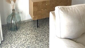 Un salon moderne avec un canapé blanc, une console en bois et trois miroirs fixés au mur.