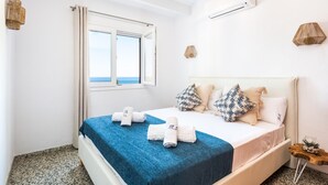 Une chambre à coucher avec un lit, une fenêtre et une vue sur la mer.