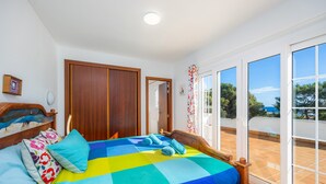 A bedroom with a bed, a wooden headboard, a window, and a door. - Villa "Luna" with Sea Views, Pool, Air Conditioning, Terraces & Garden (Cala d'Or)