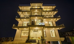 A multi-story building with a sign for 'treebo trend Ortu Residency'. - Treebo Ortus Residency (Dharamshala)