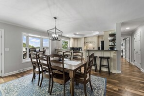 A spacious kitchen with a central island, wooden chairs, and a dining table. - Lakatude Adjustment - Lakefront w/Dock & Kid's Zone (Lake Ozark)