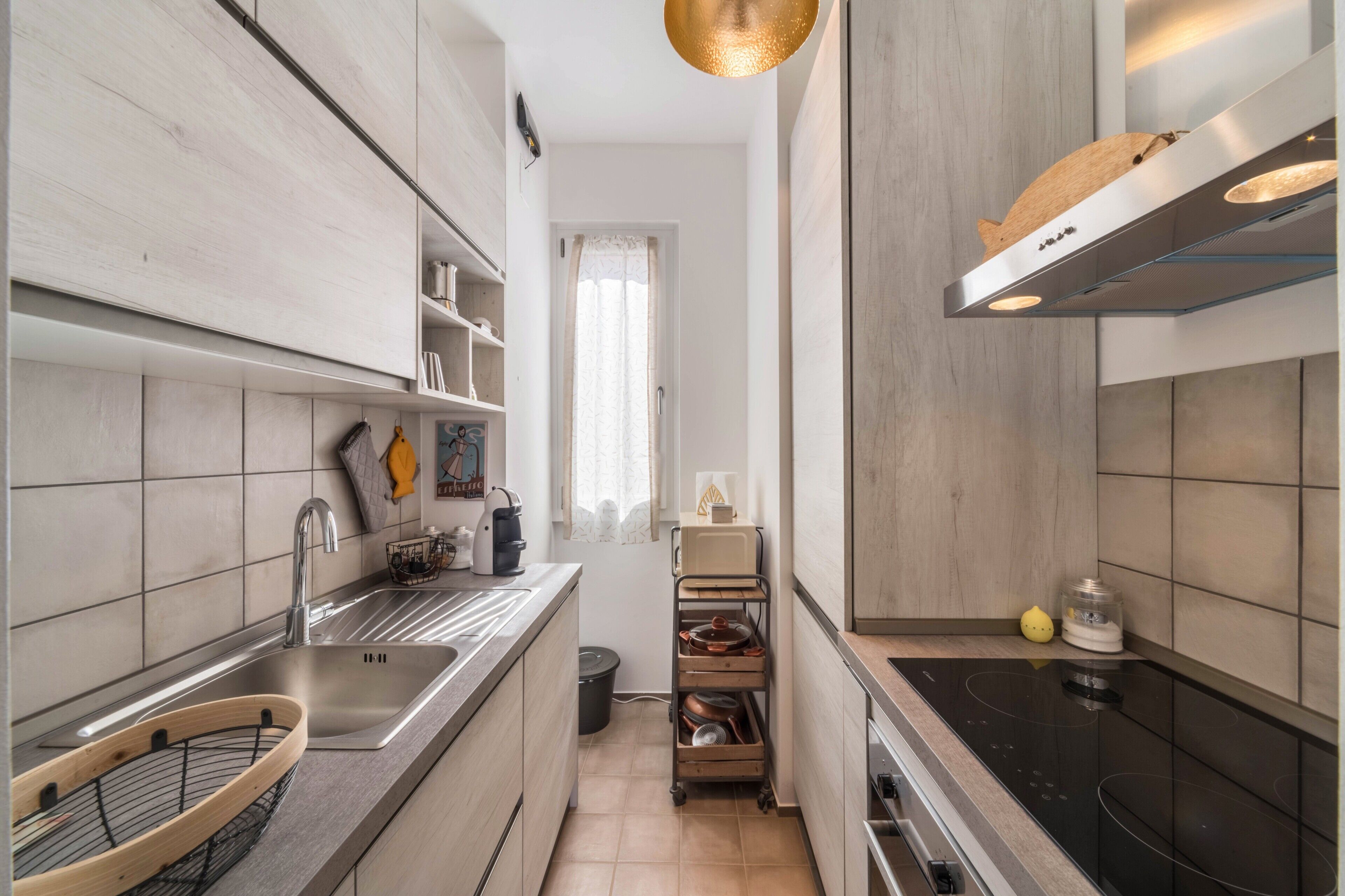Een moderne keuken met een roestvrijstalen spoelbak, een inbouwoven en een zwart fornuis.
