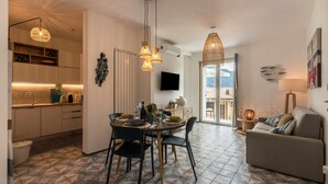 Ein modernes Wohnzimmer mit Essbereich, Küche und Sitzgelegenheiten.