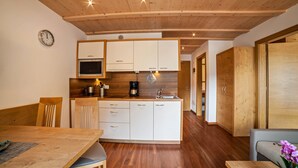 Una cucina moderna con mobili in legno, un tavolo da pranzo, sedie e una macchina per il caffè.