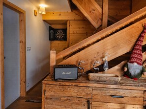 Interior de madera con un escritorio, un dardo y una decoración de gnomo.