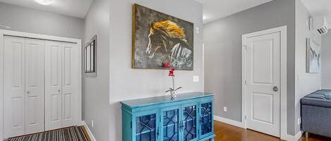 Un corridoio con un armadietto blu, un quadro e una porta.