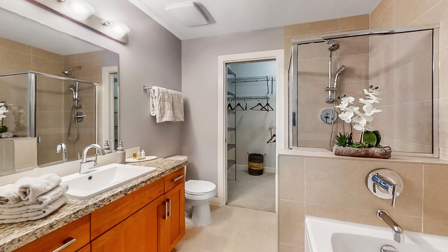 A modern bathroom with a vanity, sink, and shower.
