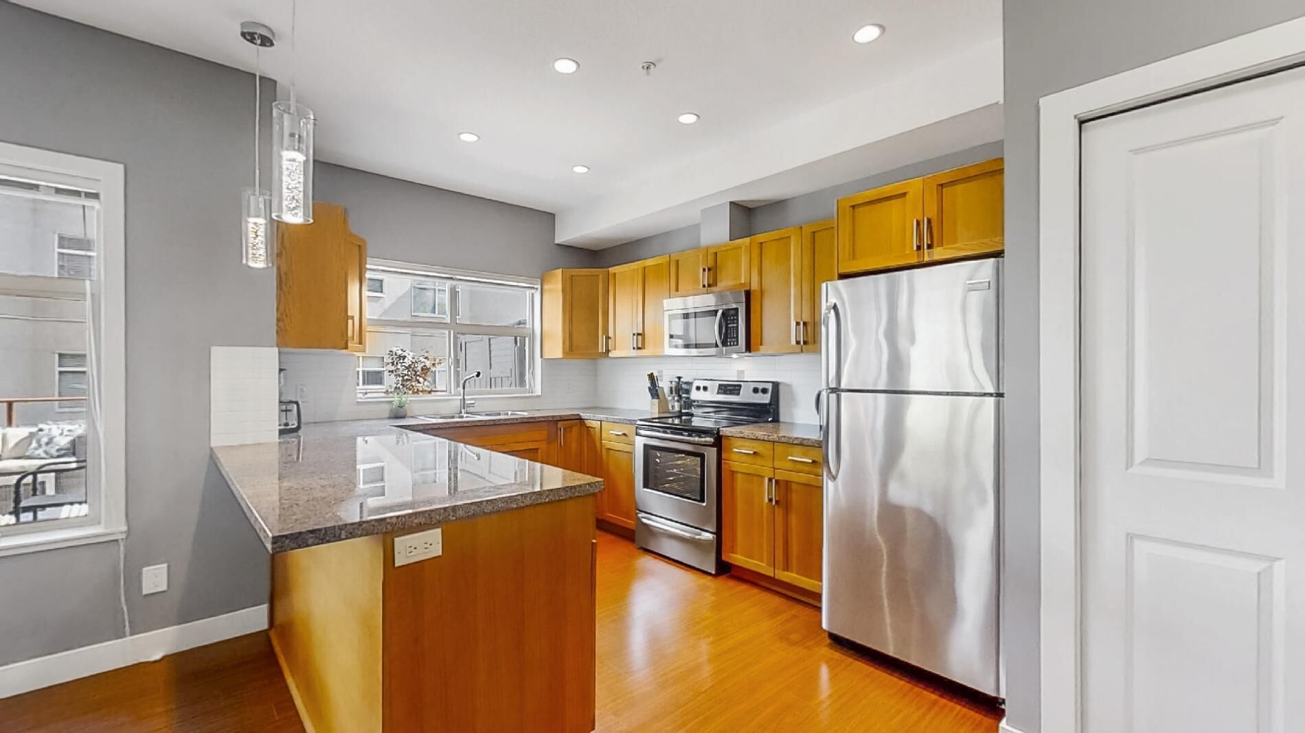 A modern kitchen with wooden cabinets, stainless steel appliances, and a large island.