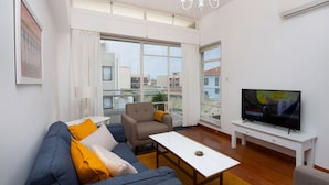 Una sala de estar moderna con un sofá, un sillón y un televisor.