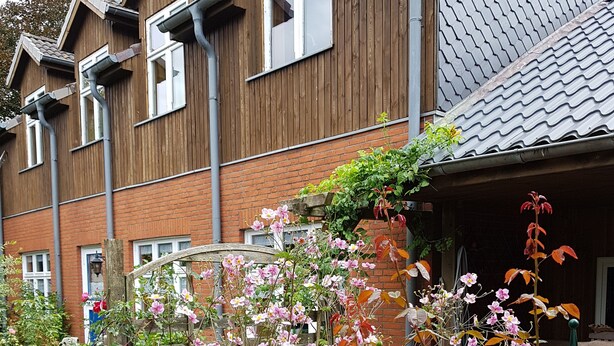 Ein Holzhaus mit Garten davor.
