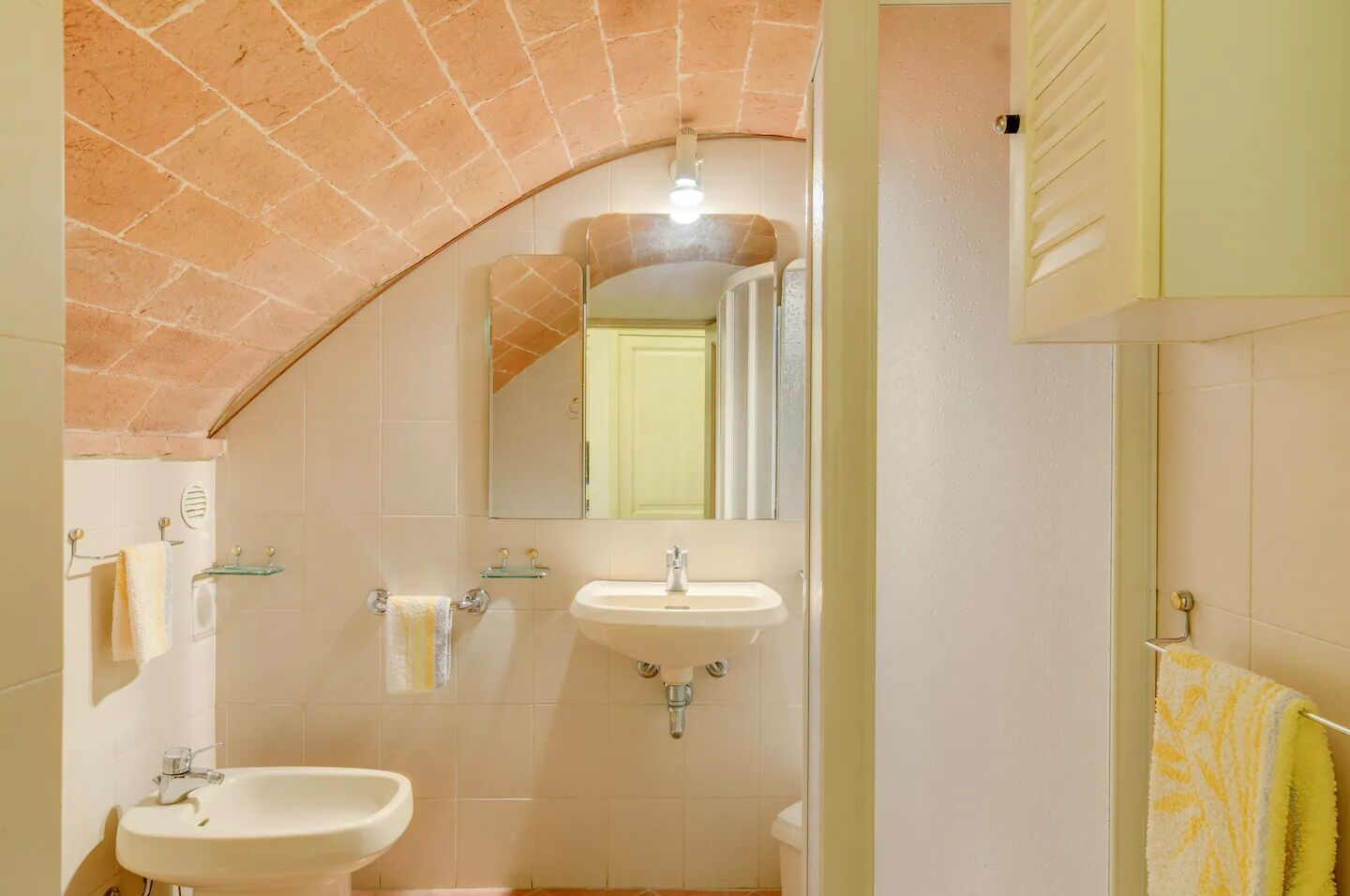 Casa de banho com duas pias, um espelho e zona de duche.
