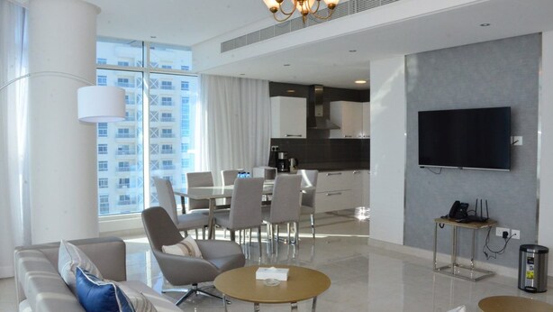 Una habitación de hotel moderna con zona de estar, comedor y cocina.