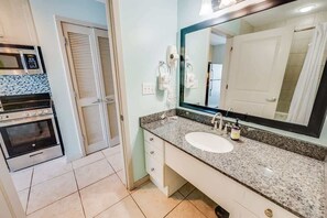 A bathroom with a sink, mirror, and hairdryer.