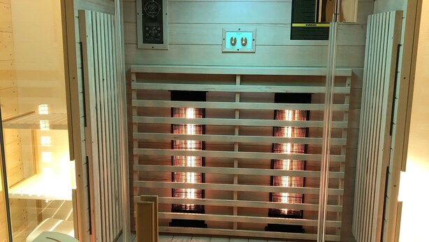 A sauna with wooden slats and a control panel above.