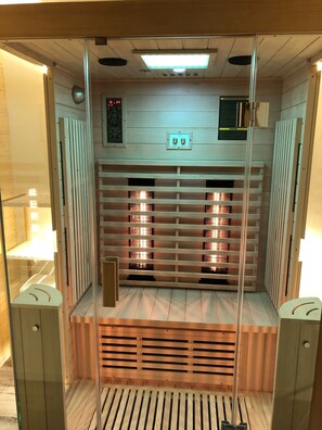 Un sauna avec des parois en bois et un panneau de commande situé en hauteur.