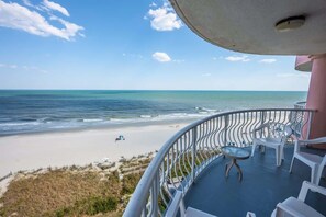 Ein Balkon mit Blick auf Strand und Meer.