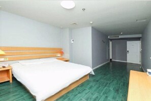 A hotel room with a bed, wooden headboard, bedside tables, and a green floor. - Home Inn Beijing West Railway Station Liuli Bridge (Beijing)