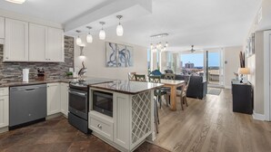 Una cocina moderna con armarios blancos, una isla central y un comedor con vistas.