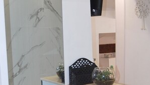 A modern staircase with marble steps and a glass panel.