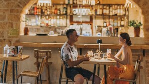 A bar restaurant named 'In Pietra' with stone walls, wooden furniture, and a bar area with bottles and glasses. - Brazzo di Maina (East Mani)