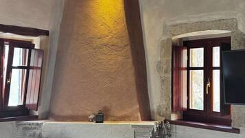 Una sala de estar acogedora con chimenea, vigas de madera en el techo y dos sillones.