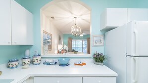 A kitchen with white cabinets, a blue countertop, and a chandelier. There are jars and a bowl on the counter. - Beautiful Golf Villa, 2.7 Miles To Beach + Free Attraction Tickets! (North Myrtle Beach)