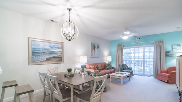 A spacious living room with a dining area, a large window with curtains, and a ceiling fan. - Beautiful Golf Villa, 2.7 Miles To Beach + Free Attraction Tickets! (North Myrtle Beach)