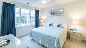A bedroom with a bed, nightstands, a ceiling fan, a window with curtains, and a small table with a decorative item. - Beautiful Golf Villa, 2.7 Miles To Beach + Free Attraction Tickets! (North Myrtle Beach)