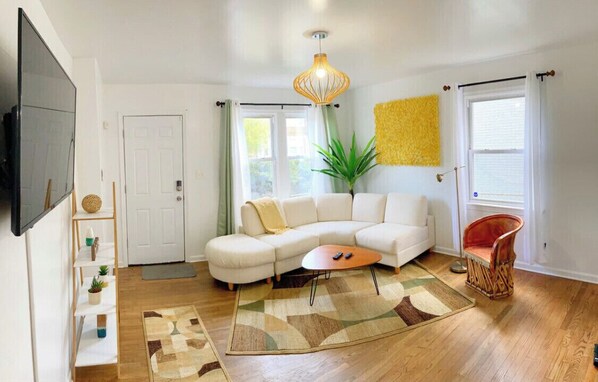 Relax in this stylish living room with a large L-shaped sofa, wooden coffee table, and unique pendant light.