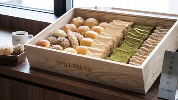 A wooden box labeled 'STYLE BREAD' containing various types of bread.