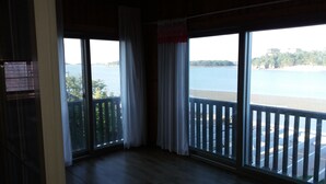 A room with large windows overlooking a beach and water. - Marina Pension (Ansan)