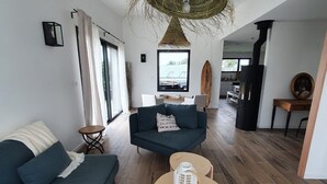 Ein modernes Wohnzimmer mit einer Couch, einem runden Tisch und einer Pendelleuchte.