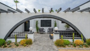 An outdoor patio with two chairs and a table, surrounded by plants and a stone pathway. - Large Pool and Entertainers Delight Yard! (Phoenix)
