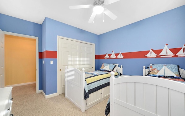 Quarto com cama, porta branca e ventilador de teto.