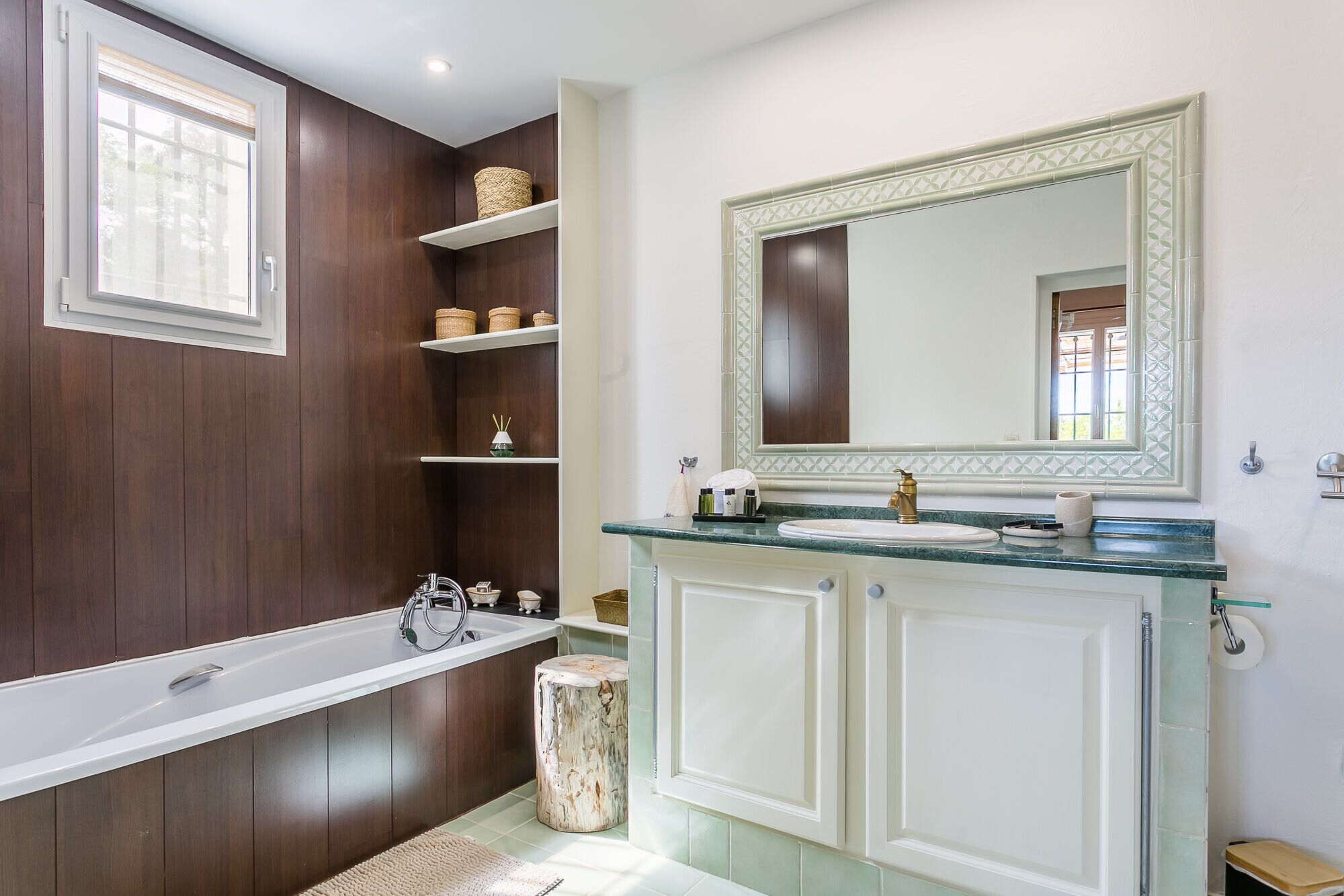 A bathroom with a freestanding bathtub, a vanity with a mirror, and built-in shelves with baskets.