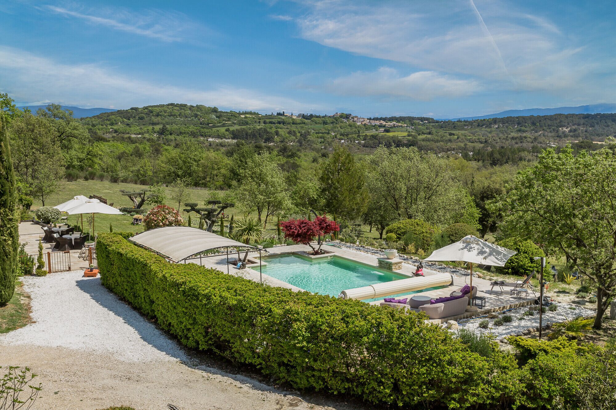 A pool area with a clear view of the surrounding landscape, including a path leading to the pool and outdoor seating.